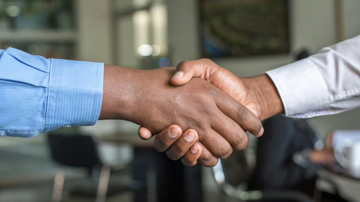 Business partners shaking hands after hiring reliable bookkeeping and tax firm - Snipay