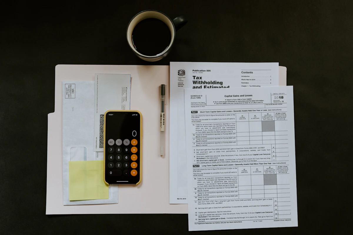 Tax forms, glasses, and a pen on a desk highlighting the online tax filing in Canada FAQ for 2026
